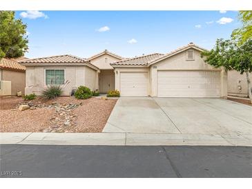 Charming single-story home with a two-car garage, desert landscaping, and a tile roof at 9539 Iris Flat Ct, Las Vegas, NV 89178