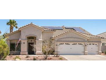 Charming single-story home featuring a two-car garage, desert landscaping, and solar panels on a tile roof at 90 Ancient Hills Ln, Henderson, NV 89074