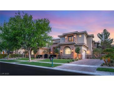 Stunning two-story home featuring stone accents, well-manicured landscaping, and a brick-paved driveway at 15 Vintage Canyon St, Las Vegas, NV 89141