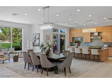 Bright dining room with modern light fixture and golf course view at 1613 Iron Ridge Dr, Las Vegas, NV 89117