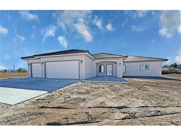 Attractive single-story home features a three-car garage, tile roof, and well-lit entryway at 2201 W Wisteria Way, Pahrump, NV 89048