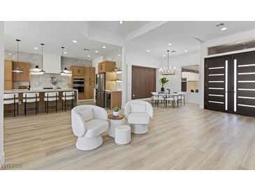 Open-concept living room with a view of a modern kitchen, breakfast nook, and stylish decor with light flooring at 2317 Sierra Heights Dr, Las Vegas, NV 89134