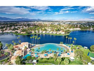 Stunning aerial view of the community's lagoon with sandy beach, mature landscaping, and lake access at 3151 Soaring Gulls Dr # 2035, Las Vegas, NV 89128