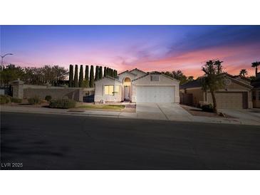 Charming single-story home with a well-manicured front yard and two-car garage at dusk at 3197 Castle Canyon Ave, Henderson, NV 89052