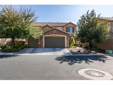 Beautiful two-story home with a three-car garage, stone accents and mature trees enhancing curb appeal at 6470 Crest Estates St, Las Vegas, NV 89131