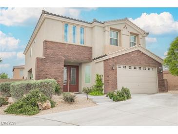Beautiful two-story home with a two car garage, lush front yard, and brick accents at 9373 Oxbow Lake Ave, Las Vegas, NV 89149