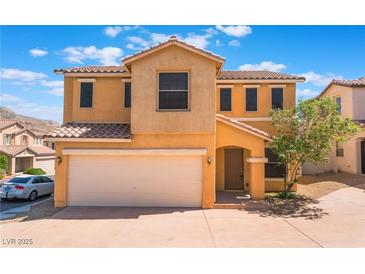 Two-story home featuring a two car garage, neutral stucco, and a red tile roof at 10457 Armand Ave, Las Vegas, NV 89129