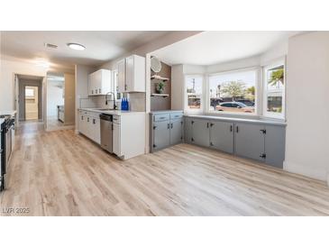 Bright kitchen featuring white cabinets, stainless steel appliances and a bay window with built-in storage at 1202 Arrowhead Ave, Las Vegas, NV 89106