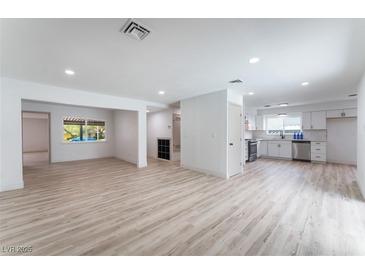 Open-concept living room and kitchen with light wood flooring, recessed lighting, and neutral color scheme at 1808 E Saint Louis Ave, Las Vegas, NV 89104