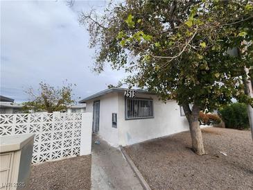 Modest single-story home featuring a white stucco facade and desert landscaping at 2513 Cedar Ave, Las Vegas, NV 89101