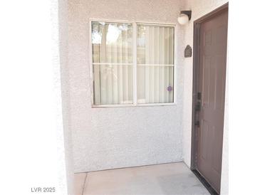 The unit entrance features neutral stucco and a window with privacy blinds at 2615 W Gary Ave # 1015, Las Vegas, NV 89123