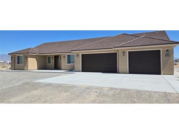 A single-story home has a tile roof, two-car garage, and desert landscaping at 3761 S Tumbleweed Ave, Pahrump, NV 89048