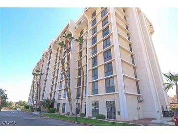 A multi-story building with classic architecture is surrounded by green space and trees, a clear blue sky at 3930 University Center Dr # 409, Las Vegas, NV 89119