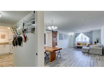 Bright living room and kitchen features modern decor, an open layout, and whitewashed wood flooring at 3930 University Center Dr # 409, Las Vegas, NV 89119