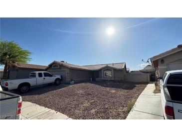 Charming single-story home featuring a low maintenance yard, neutral stucco facade and an attached two-car garage at 5135 Shimmering Peak Way, North Las Vegas, NV 89031