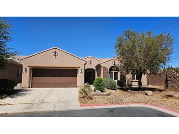Charming single-story home with a well-manicured front yard and a two-car garage at 5772 Flying Birdie Ave, Las Vegas, NV 89122