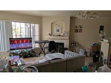 Comfortable living room with a fireplace, large windows, and tile floors at 7155 S Durango Dr # 205, Las Vegas, NV 89113