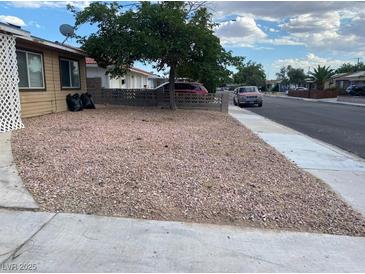 View of the residence showcasing the desert landscaping and mature shade tree at 805 Slayton Dr, Las Vegas, NV 89107
