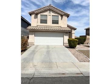 Charming two-story home with a white garage door and desert landscaping at 4708 Grand Rock Dr, North Las Vegas, NV 89081