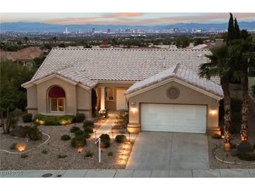 Charming single-story home with a tile roof, two-car garage, and stunning city views in the background at 2728 Faiss Dr, Las Vegas, NV 89134