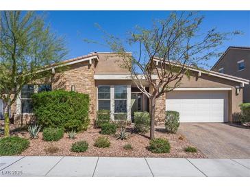Charming single-story home featuring a stone facade, tile roof, desert landscaping, and an attached two-car garage at 8440 Footpath St, Las Vegas, NV 89166
