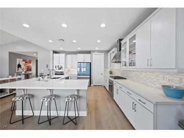 Bright kitchen features a large island with seating, modern appliances, and white cabinets at 8440 Footpath St, Las Vegas, NV 89166