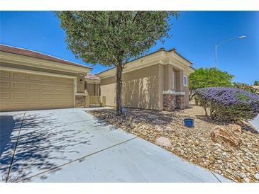 Inviting single-story home showcasing drought-resistant landscaping, neutral tones, and a convenient two-car garage at 2213 Carrier Dove Way, North Las Vegas, NV 89084