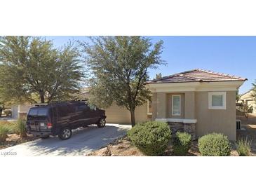 Charming single-story home with a tile roof, desert landscaping, and inviting curb appeal on a sunny day at 2213 Carrier Dove Way, North Las Vegas, NV 89084