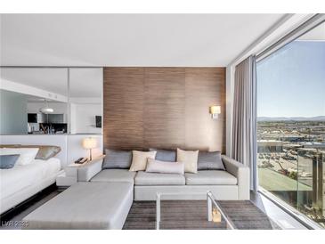 Bright living room featuring a comfortable sofa, stylish decor, and expansive window views at 4381 W Flamingo Rd # 1003, Las Vegas, NV 89103