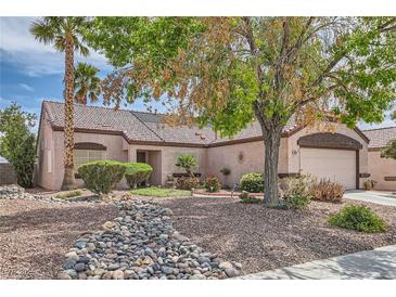 Charming single-story home featuring desert landscaping, a tiled roof, and an attached two-car garage at 6048 Pele St, North Las Vegas, NV 89031