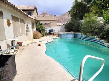 Inviting backyard pool with a spa, surrounded by lush landscaping and mountain views at 6435 Heatherton Ave, Las Vegas, NV 89110