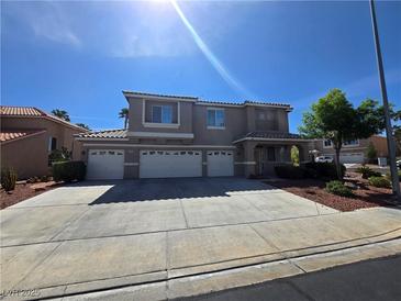 Two-story home with a three-car garage and beautiful landscaping on a sunny day at 669 Kentons Run Ave, Henderson, NV 89052