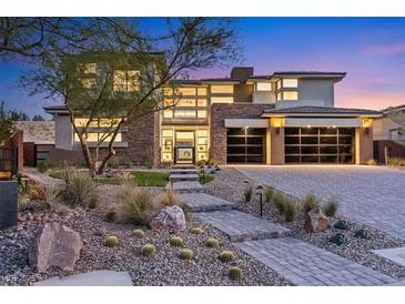Beautiful home showcasing stone accents, a modern garage door, and landscaped front yard at 82 Glade Hollow Dr, Las Vegas, NV 89135