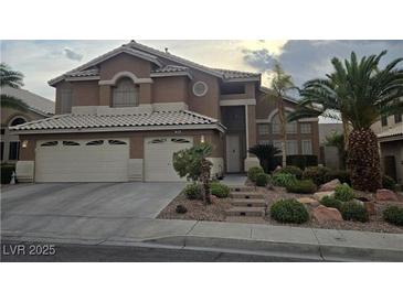 Inviting two-story home featuring a two-car garage, mature landscaping, and a charming entrance at 283 Grand Olympia Dr, Henderson, NV 89012