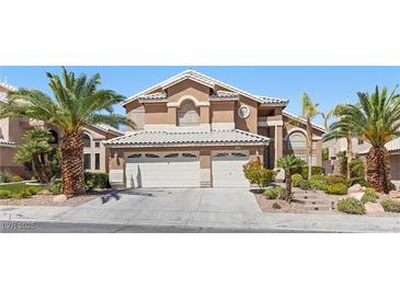 Two-story home with a two-car garage, desert landscaping, and palm trees at 283 Grand Olympia Dr, Henderson, NV 89012