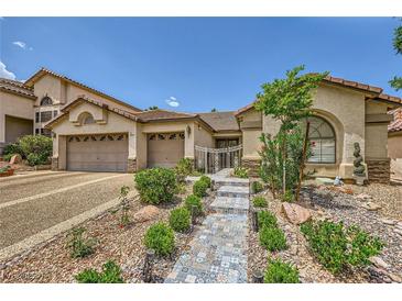 Charming single-story home with landscaped front yard and tiled walkway to the gated entrance at 521 Dawn Cove Dr, Henderson, NV 89052