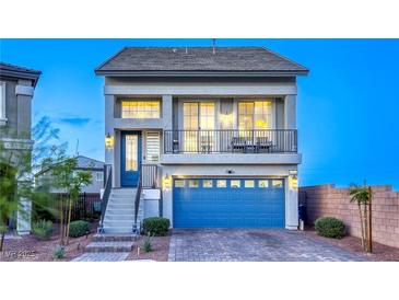 Charming two-story home featuring a blue door, balcony, blue garage door, and low-maintenance front yard at 5368 Knitmore Ct, Las Vegas, NV 89139