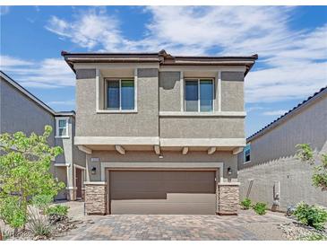 Charming two-story home featuring a paver driveway, attached two car garage and neutral exterior at 10038 W Meranto Ave, Las Vegas, NV 89178