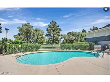 Refreshing community pool with lounge chairs and view of the golf course on a sunny day at 2831 Geary Pl # 2918, Las Vegas, NV 89109