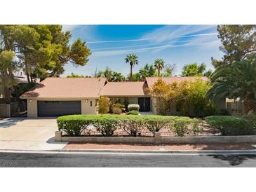Charming single-story home featuring lush landscaping and a well-manicured lawn on a sunny day at 3007 La Mesa Dr, Henderson, NV 89014