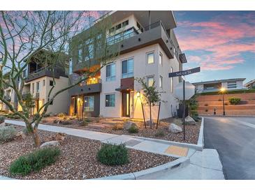 Contemporary three-story home with modern design and inviting front landscape at sunset at 4193 Solace St # 4193, Las Vegas, NV 89135