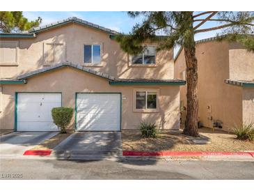 Charming townhome featuring attached garages, manicured landscaping, and a welcoming facade at 5612 Coder Ct, Las Vegas, NV 89118