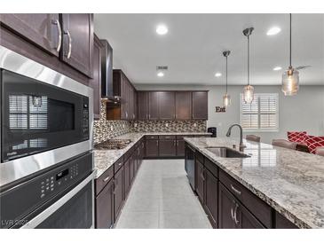 Beautiful kitchen with granite countertops, stainless steel appliances, and dark wood cabinets at 6331 Regina Ridge St, Las Vegas, NV 89149