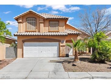 Inviting two-story home featuring a white garage door, complemented by desert landscaping and a tiled roof at 7954 Kentshire Dr, Las Vegas, NV 89117