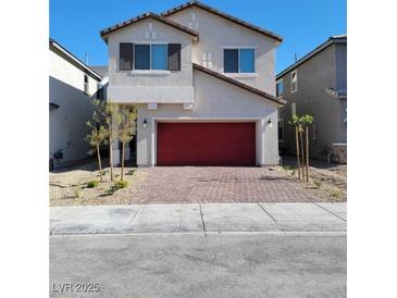 Inviting two-story home with a red garage door and a well-manicured front yard at 9159 Oxford Blue Ave, Las Vegas, NV 89148