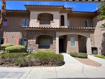Inviting condo with a stone facade, balcony, desert landscaping and neutral exterior paint colors at 7701 W Robindale Rd # 127, Las Vegas, NV 89113