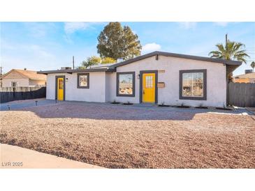 Charming single-story home featuring a freshly landscaped yard and bright yellow doors at 1720 Hassett Ave, Las Vegas, NV 89104