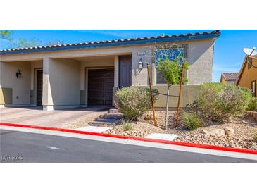 Inviting townhouse featuring a one-car garage, desert landscaping, and a quaint front entrance at 2727 Chinaberry Hill St, Laughlin, NV 89029