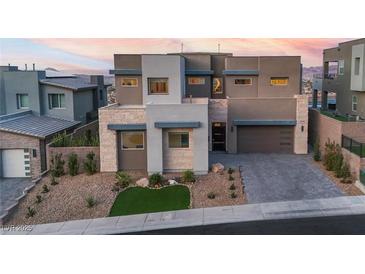 Contemporary two-story home featuring a modern design, stone accents, a well-manicured yard, and an attached garage at 286 Shaded Canyon Dr, Henderson, NV 89012