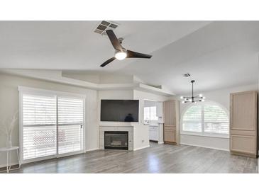 Bright living room features a fireplace, large windows, ceiling fan, and wood flooring at 3404 Winterhaven St # 204, Las Vegas, NV 89108